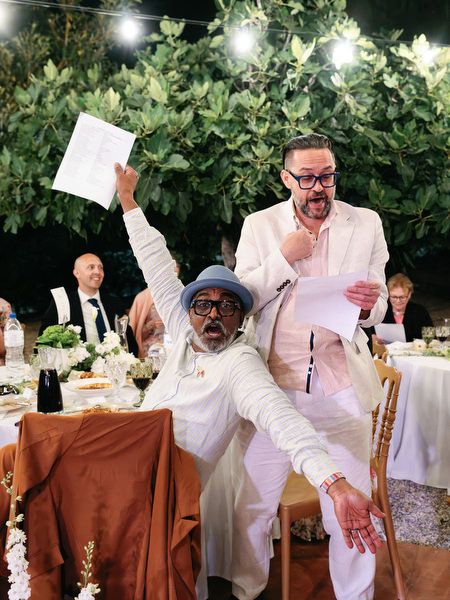 Guests laughing and reacting during a lively wedding speech at Pyrgos Ralli