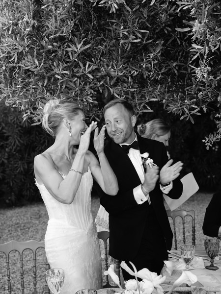 Black and white candid of the bride and groom laughing during the evening reception