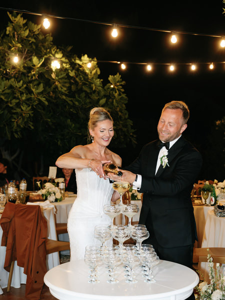 Newlyweds smiling together during the cake and champagne celebration in Aegina