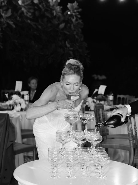 Black and white candid of the newlyweds during the champagne tower celebration