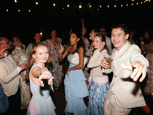 Wedding guests dancing and celebrating beneath the lights at Pyrgos Ralli