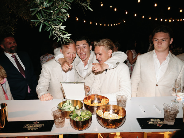 Wedding guests celebrating with drinks during the open-air reception at Pyrgos Ralli
