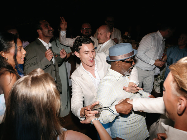 Wedding guests celebrating on the dance floor beneath warm evening lights