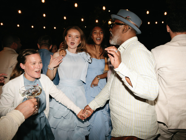 Wedding guests singing and dancing together during the open-air party in Aegina