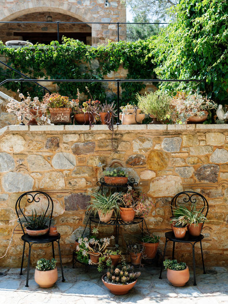 Rustic stone courtyard details with potted plants at Pyrgos Petreza