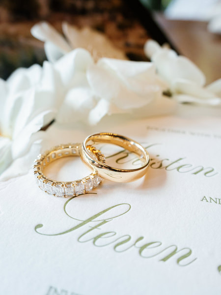 Close-up of wedding rings arranged on elegant stationery