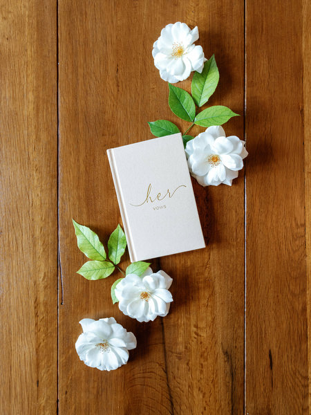 Bridal vows and white flowers styled on a wooden table at Pyrgos Petreza