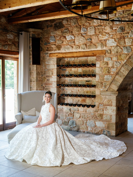Bride seated inside the rustic stone interior of Pyrgos Petreza in her wedding gown