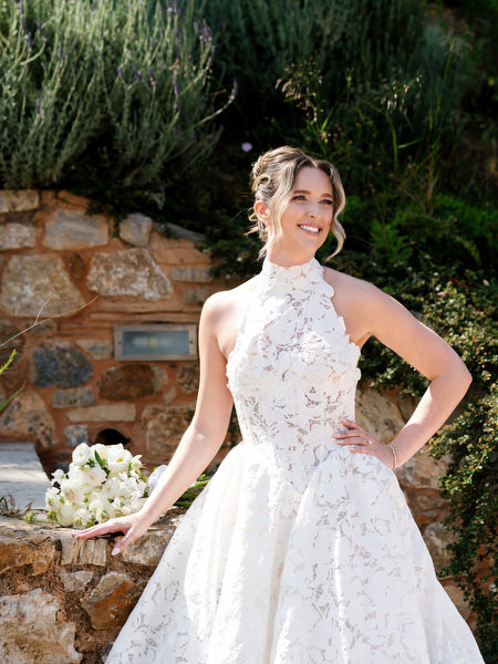 Elegant bridal portrait with the bride holding her skirt in the gardens of Pyrgos Petreza