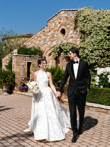 Bride and groom walking together through the courtyard during wedding portraits