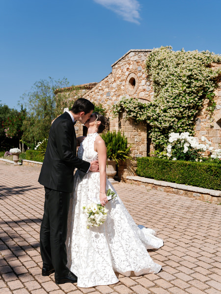 Newlyweds posing outside the stone architecture of Pyrgos Petreza near Athens
