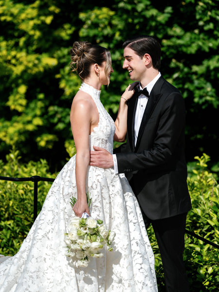 Romantic portrait of the bride and groom surrounded by lush green foliage