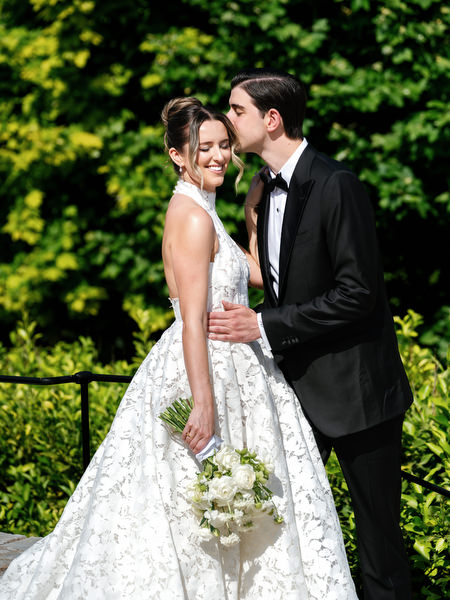 Close-up wedding portrait of the bride and groom smiling together outdoors