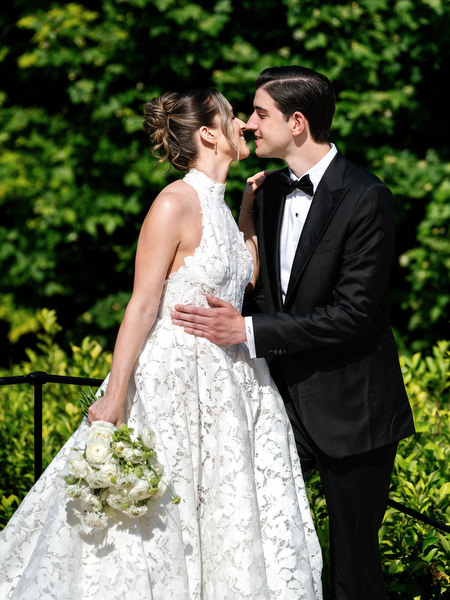 Bride and groom embracing beneath greenery during romantic Pyrgos Petreza portraits