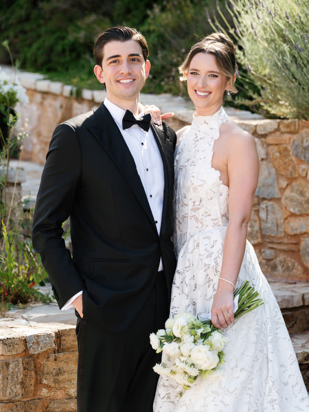 Bride and groom smiling during an elegant portrait outside the venue
