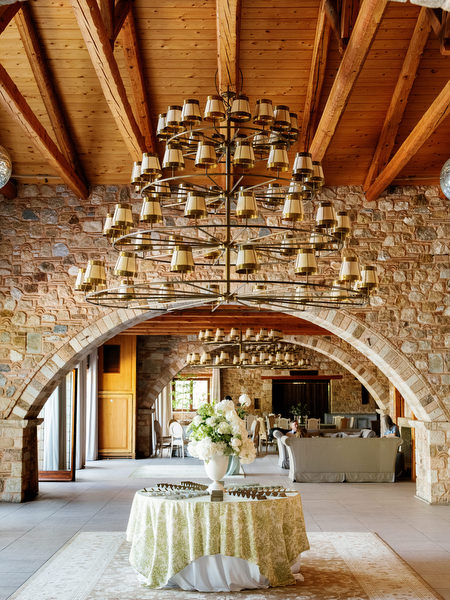 Wide interior view of the stone arches and chandeliers at Pyrgos Petreza