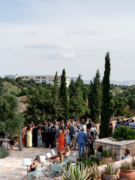 Wedding guests gathering outdoors before the ceremony at Pyrgos Petreza