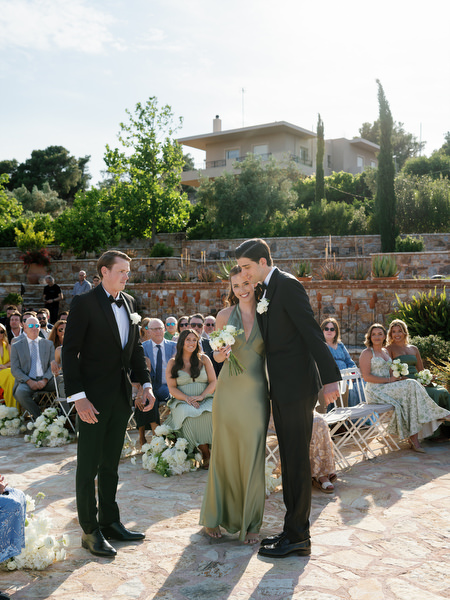 Wedding party walking together toward the ceremony at Pyrgos Petreza