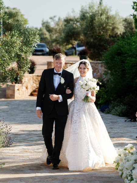 Bride escorted by her father walking through the Pyrgos Petreza ceremony space