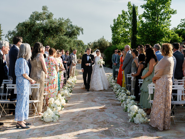 Bride walking through the flower-lined aisle during her romantic Athens wedding