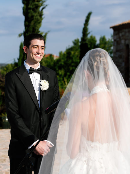 Groom smiling as the bride approaches during their Pyrgos Petreza ceremony