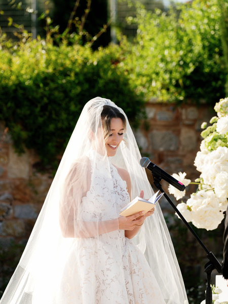 Bride smiling beneath her veil during the emotional outdoor wedding ceremony