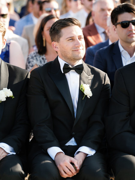 Groomsmen watching during the ceremony in their classic black tuxedo