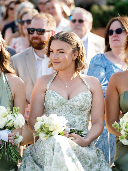 Bridesmaid smiling while holding a white bouquet during the Pyrgos Petreza wedding