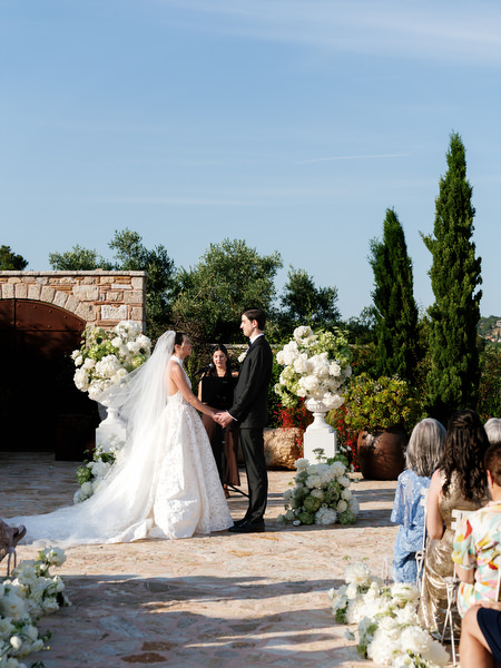 Bride and groom standing together at the altar surrounded by white florals