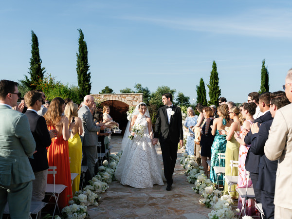 Bride and groom walking back down the aisle as guests cheer around them