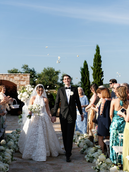 Newlyweds smiling as they exit their outdoor wedding ceremony at Pyrgos Petreza
