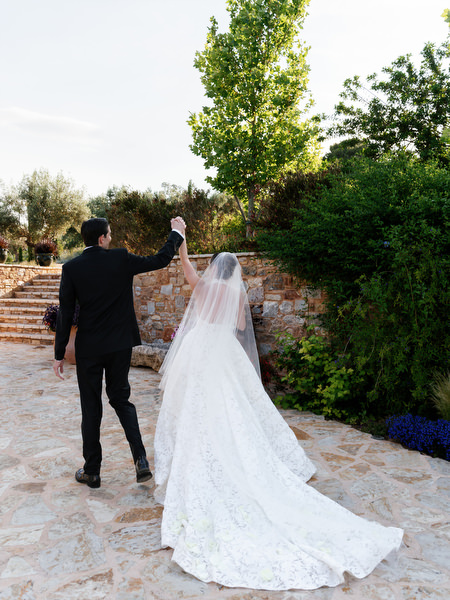 Bride and groom walking away from the ceremony with her veil flowing behind them
