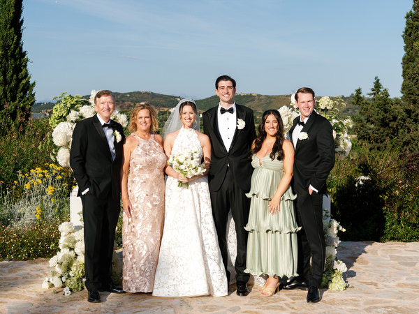 Bride, groom and close family posing together after the outdoor ceremony