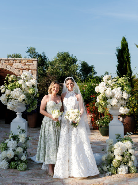 Bride and groom standing with their wedding party beneath the Greek summer sky