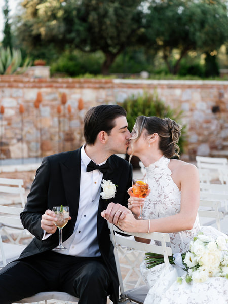 Bride and groom sharing a kiss while seated together after the ceremony