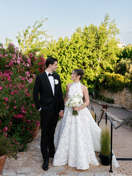 Romantic portrait of the newlyweds surrounded by pink bougainvillea and greenery
