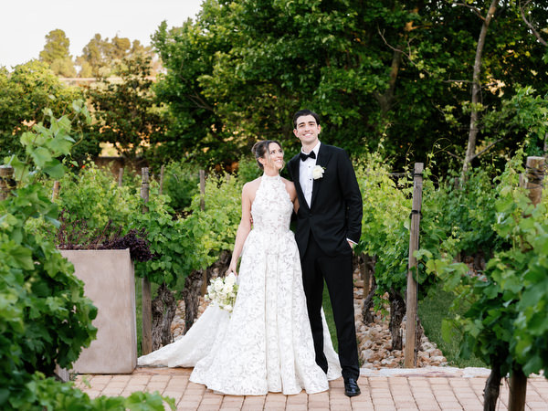 Bride and groom walking through the vineyard gardens during golden-hour portraits