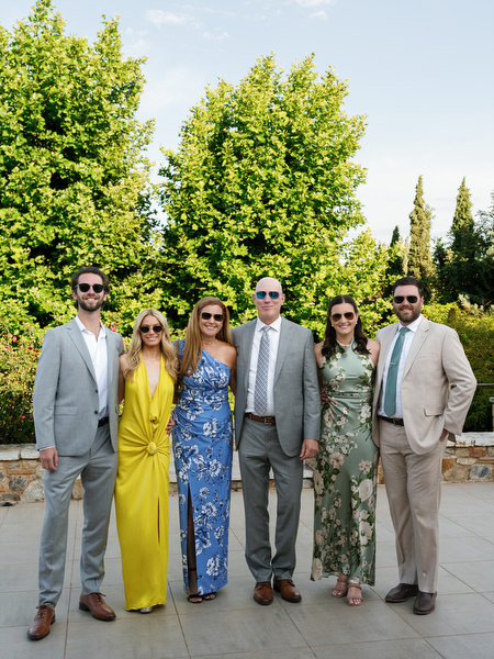 Group of wedding guests posing together in the gardens at Pyrgos Petreza