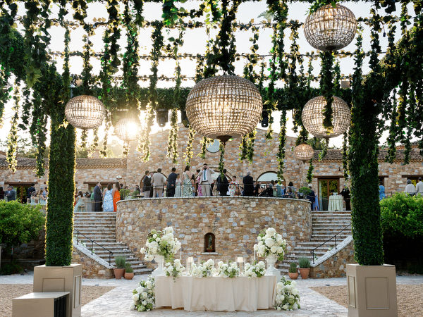 Elegant sweetheart table beneath hanging greenery and woven lights at Pyrgos Petreza