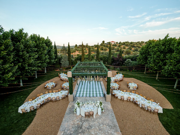 Wide elevated view of the al fresco reception setup at Pyrgos Petreza