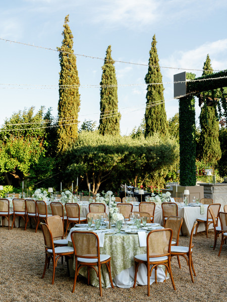 Elegant reception tables surrounded by cypress trees and Mediterranean greenery