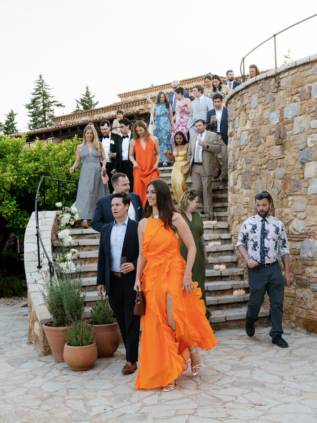Group of wedding guests walking through the stone courtyard at Pyrgos Petreza