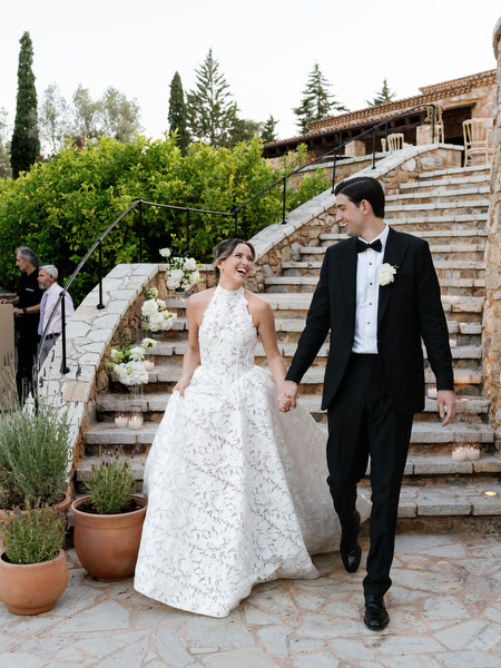 Newlyweds smiling as they enter the reception area at Pyrgos Petreza