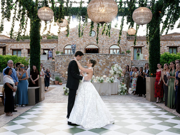 Bride and groom dancing in the center of the elegant outdoor reception