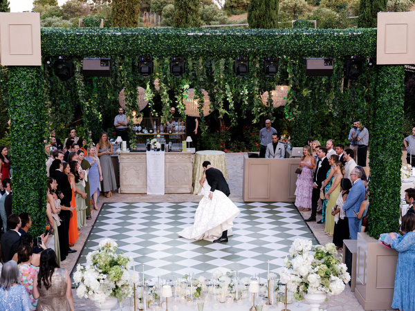 Bride and groom finishing their first dance as guests look on