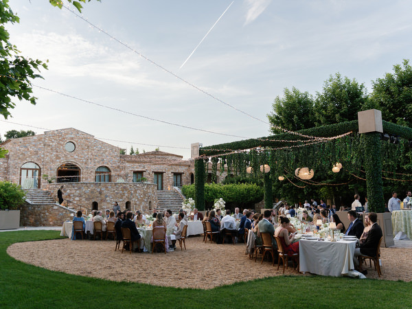 Guests seated around the reception tables as evening begins at Pyrgos Petreza