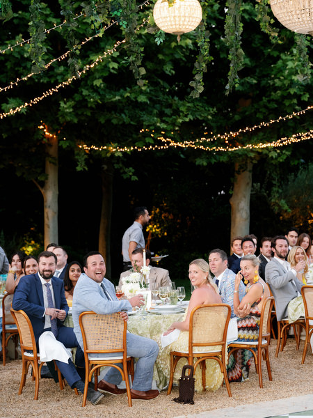 Guests enjoying the candlelit al fresco dinner beneath string lights
