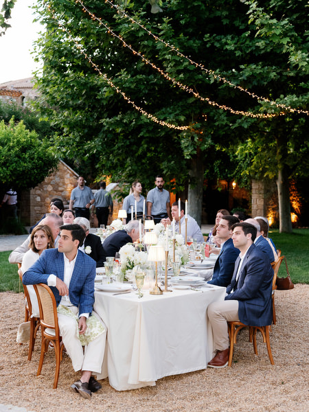 Wedding guests laughing together around the dinner tables at Pyrgos Petreza