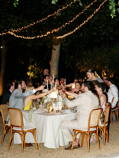 Guests dining beneath warm string lights during the Pyrgos Petreza wedding