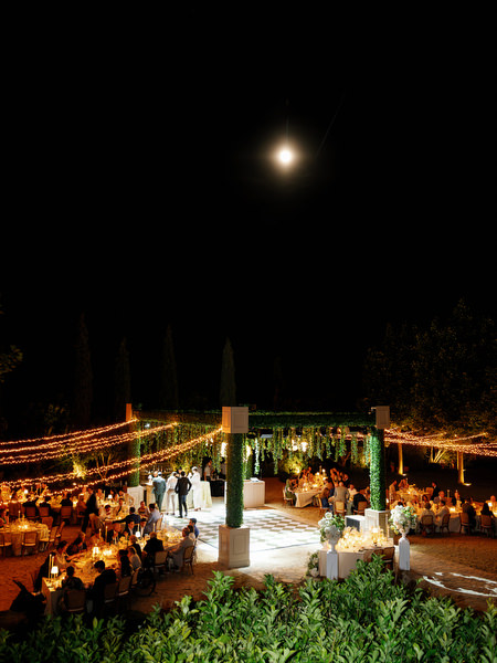 Night view of the illuminated outdoor reception beneath the moon